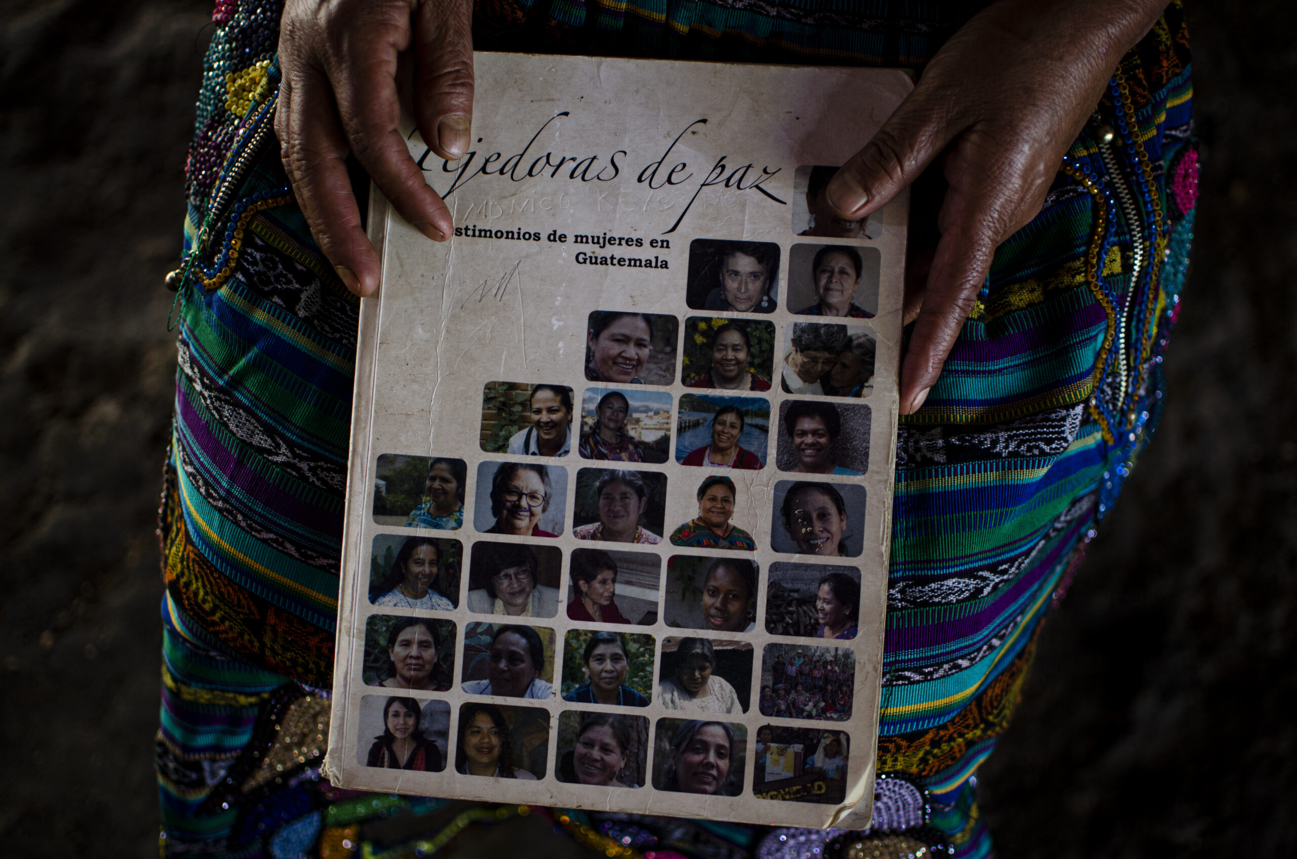 Juana sostiene el libro “Tejedoras de paz” donde se encuentran relatadas las historias de varias mujeres defensoras de los derechos humanos, incluida su historia. Foto: Melissa Miranda